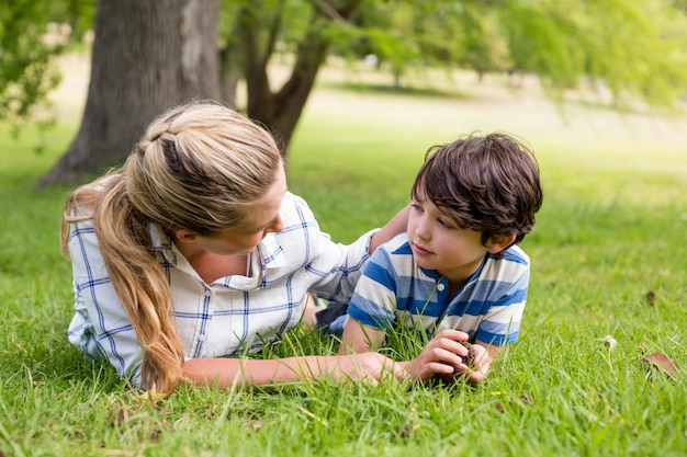 Feliz madre e hijo tumbado en el parque