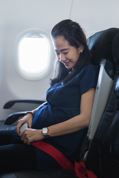 Feliz madre embarazada disfruta de vuelo de seguridad