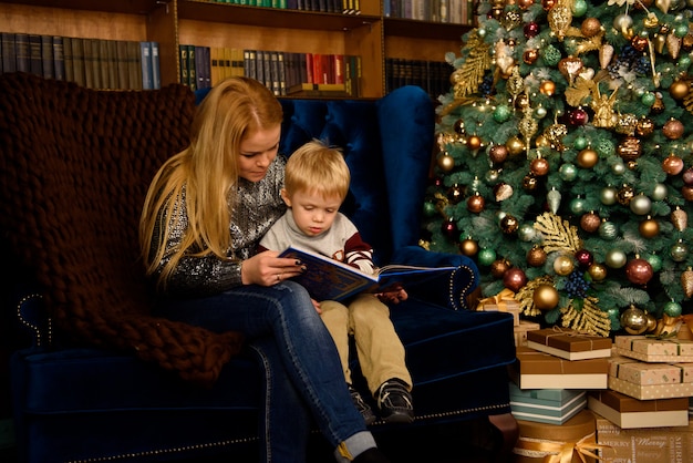 Feliz madre de familia y bebé jugando en casa durante las vacaciones de Navidad