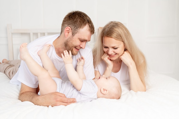 Feliz madre de familia, padre y bebé en casa divirtiéndose, bebé gateando en primer plano