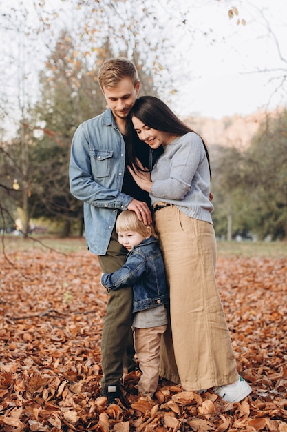 Feliz madre de familia, padre y bebé en otoño caminan en el parque