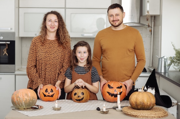 Foto feliz madre de familia, padre e hija, celebración de halloween en casa.