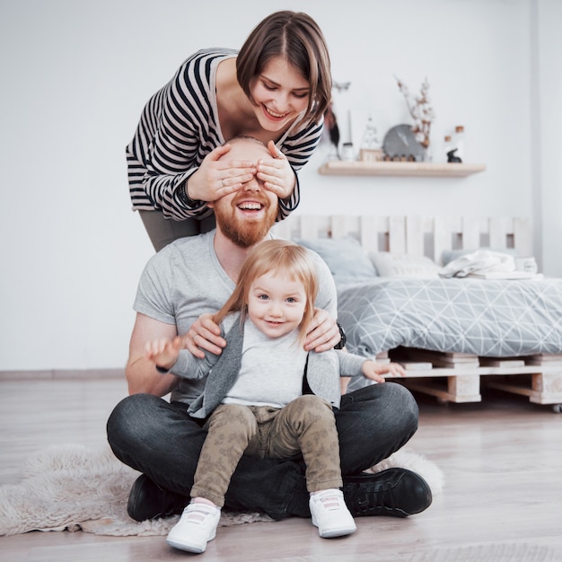 Feliz madre de familia, padre e hija hija en casa