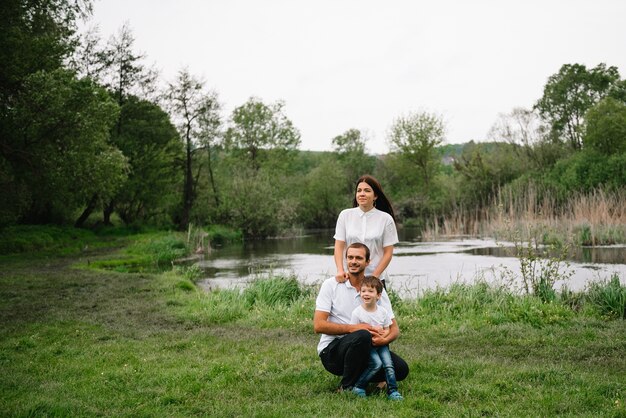 Feliz madre de familia padre e hijo en la naturaleza en la puesta de sol.