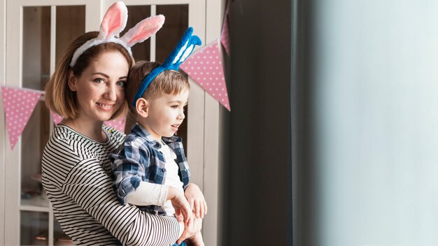 Feliz madre con niño con orejas de conejo