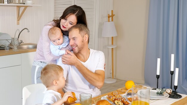 Feliz madre, padre e hijo desayunando en casa.