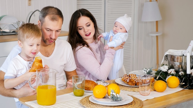 Feliz madre, padre e hijo desayunando en casa