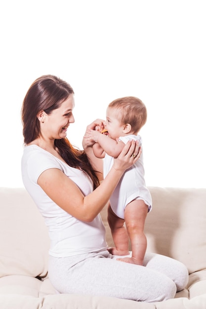 Feliz madre sonriente con bebé en el sofá