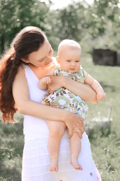 Feliz madre sostiene a una pequeña hija en sus brazos