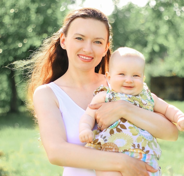 Feliz madre sostiene a una pequeña hija en sus brazos