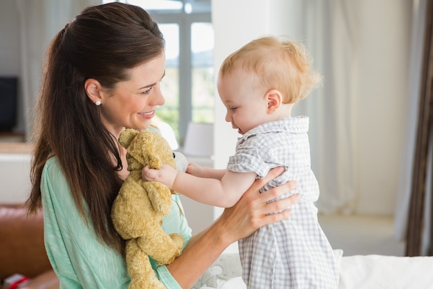 Feliz madre con su bebé en casa en el dormitorio