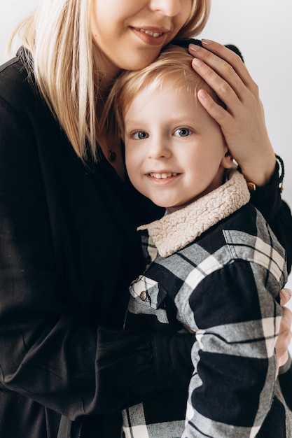 Feliz madre y su hijo sonriendo y abrazándose en la habitación