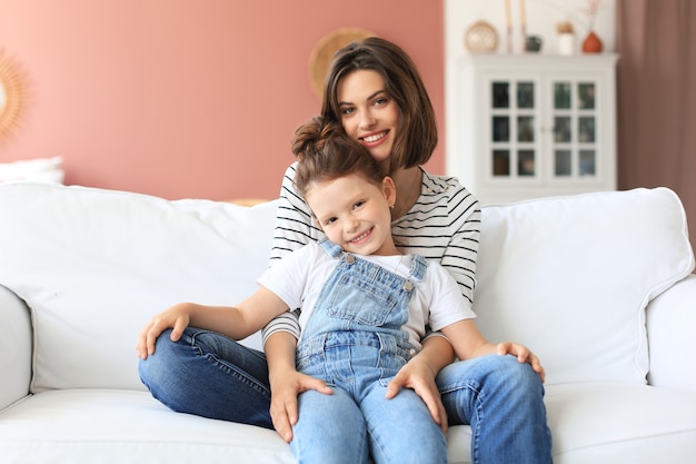 Feliz mãe amorosa abraçando a filha, passar algum tempo juntos em casa.