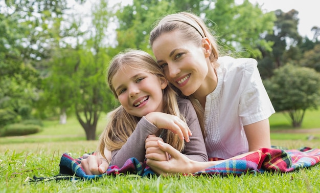 Feliz mãe com filha deitada no parque