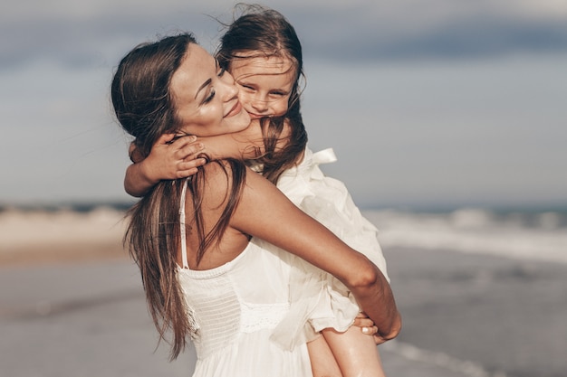 Feliz mãe e filha, aproveitando o dia ensolarado na praia