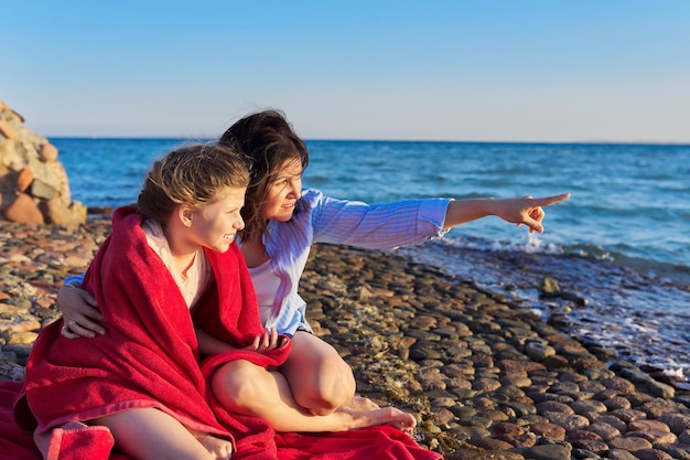 Feliz mãe e filha criança juntos na praia do mar