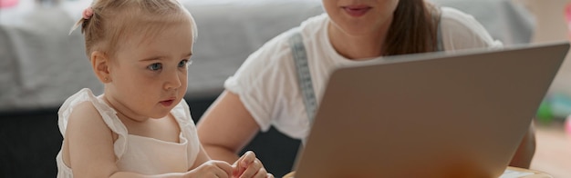 Feliz mãe e filha passando momentos de lazer e assistindo desenhos animados no laptop em casa