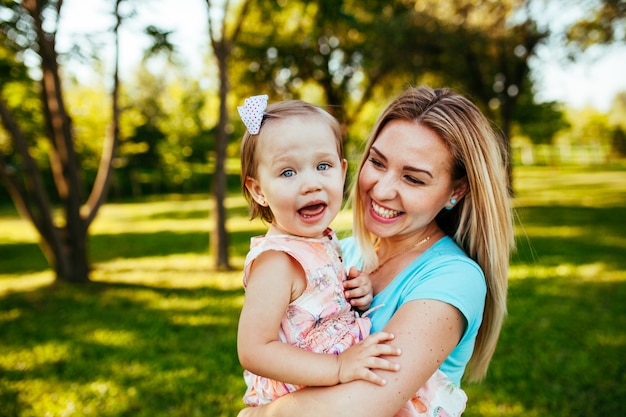 Feliz mãe e filha sorrindo para a natureza.