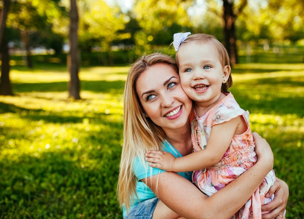 Feliz mãe e filha sorrindo para a natureza.