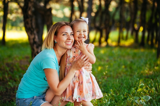 Feliz mãe e filha sorrindo para a natureza.