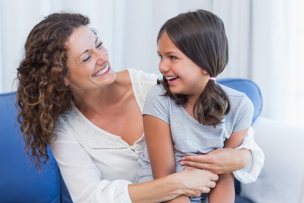 Foto feliz mãe e filha sorrindo um para o outro