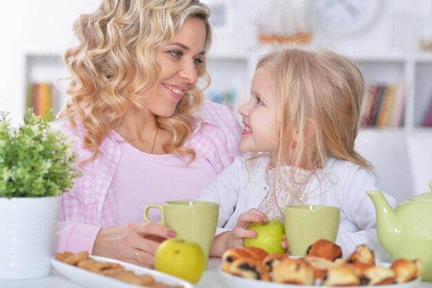 Feliz mãe e filha tomando café da manhã juntos