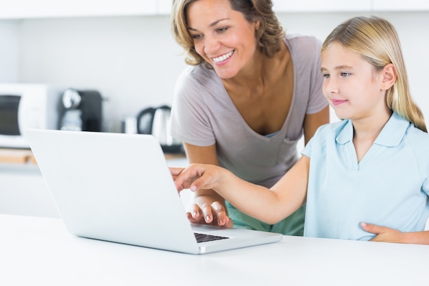 Feliz mãe e filha usando laptop