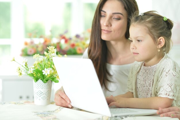 Feliz mãe e filha usando o laptop juntos