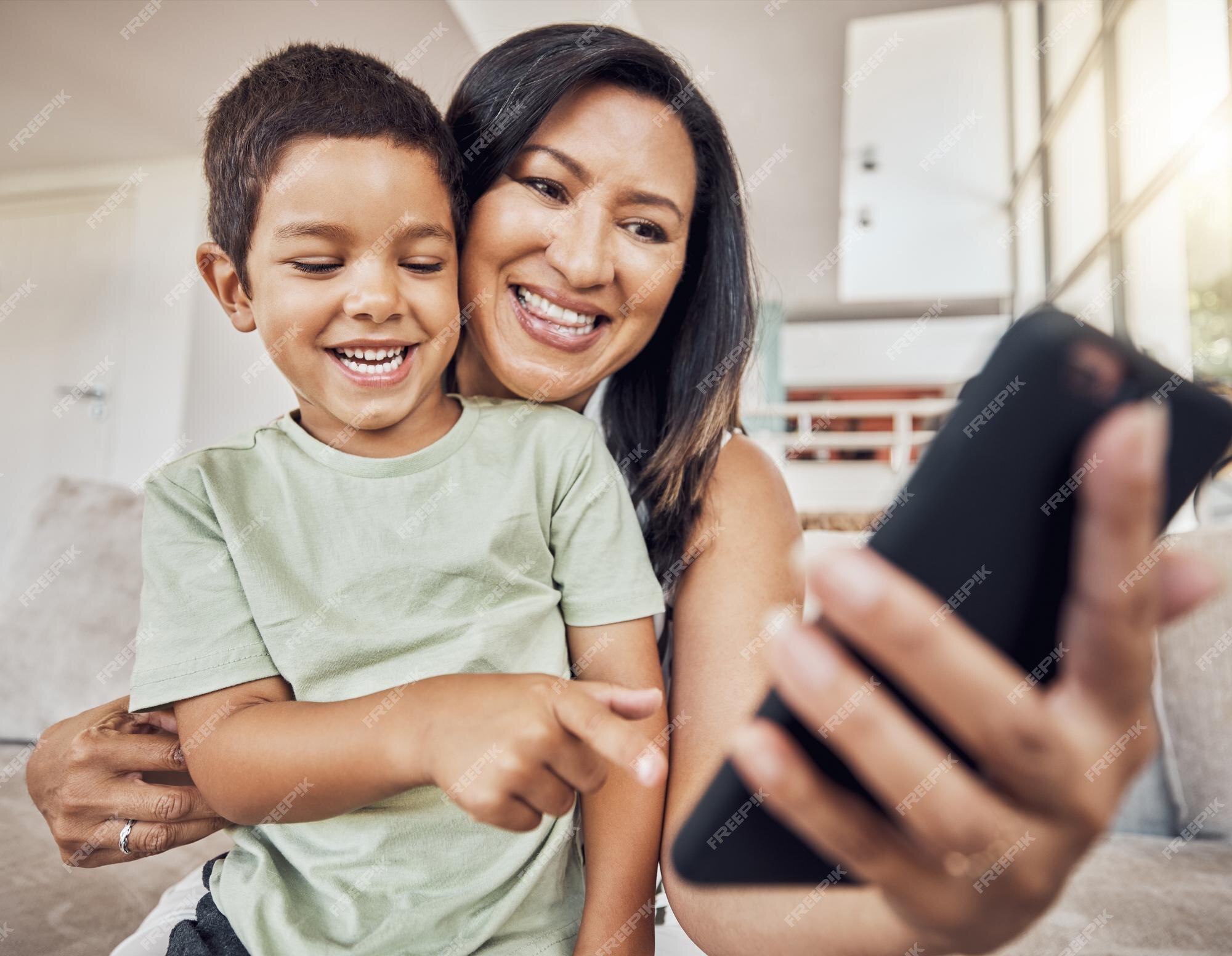 Feliz mãe e filho com smartphone no sofá para jogos aplicativo engraçado  postagem de mídia social ou site de e-learning criança com a mãe no sofá e  chamada de vídeo educacional de