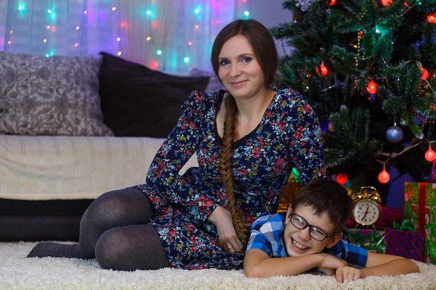 Feliz mãe e filho em casa celebram o Natal Ano Novo Árvore de Natal e presentes