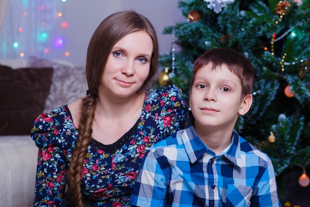 Feliz mãe e filho em casa celebram o Natal Ano Novo Árvore de Natal e presentes