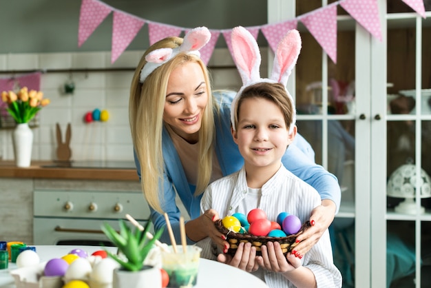 Feliz mãe e filho pequeno estão se preparando para a Páscoa, colorir ovos