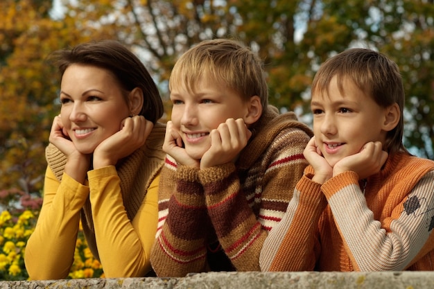 Feliz mãe e filhos no parque de outono