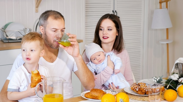 Foto feliz mãe, pai e filho tomando café da manhã em casa