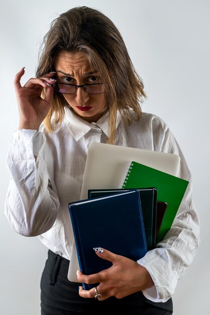 Feliz maestra o mujer de negocios sosteniendo libros y sonriendo en el fondo