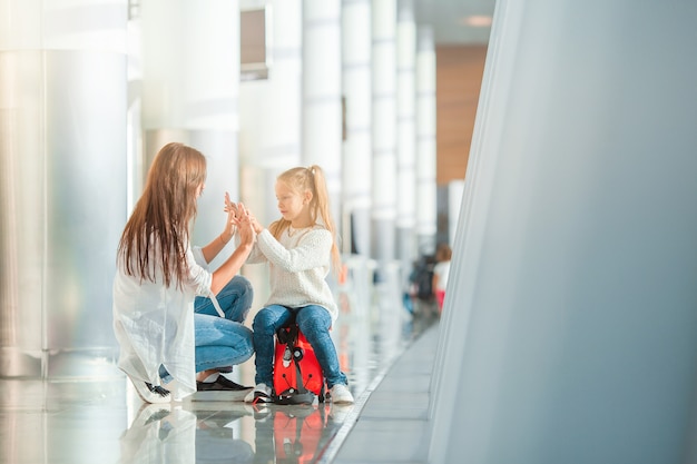 Feliz mamá y niña con tarjeta de embarque en el aeropuerto