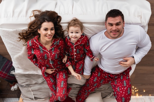 Feliz mamá papá e hija la mañana antes de Navidad