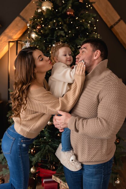 Feliz mamá papá e hija la mañana antes de Navidad