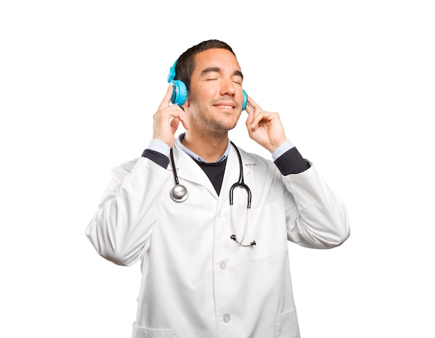 Feliz médico con auriculares contra el fondo blanco