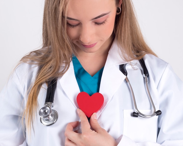 Foto feliz médico feminino com um coração vermelho, o conceito de saúde