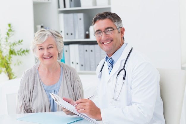 Feliz médico y paciente femenino en clínica