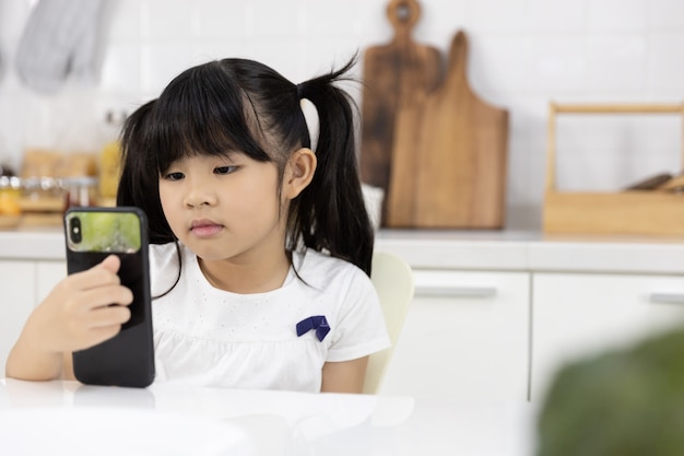 Feliz menina asiática desfrutar de smartphone