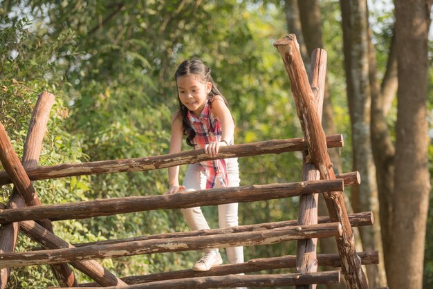 Foto feliz menina asiática se divertindo a brincar no playground no verão com sorriso e rindo saudável, engraçado sorridente rosto adorável criança feminina adorável.