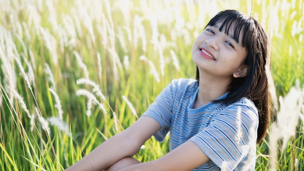Feliz menina asiática sentada na bela vista da paisagem, menina adolescente.