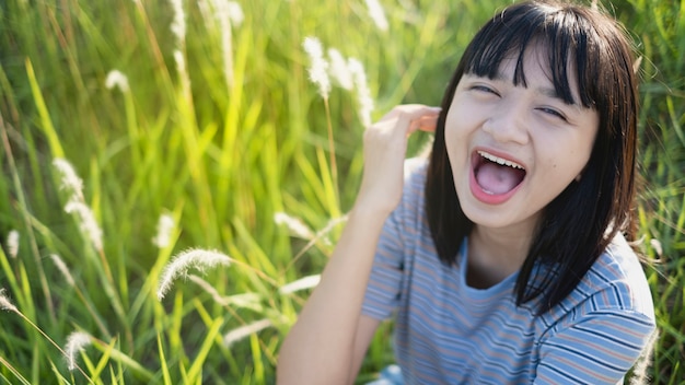 Feliz menina asiática sentada na bela vista da paisagem, menina adolescente.