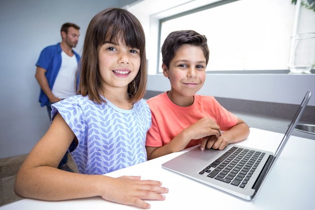 Feliz menino e menina usando laptop