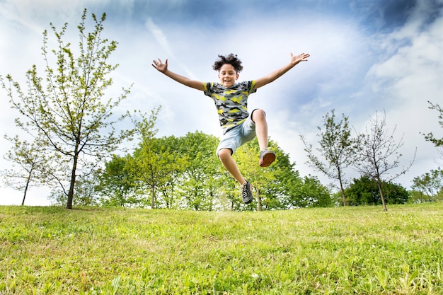 Foto feliz menino energético pulando alto no ar