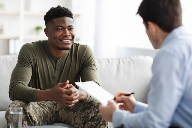 Feliz militar negro ouvindo seu psicólogo