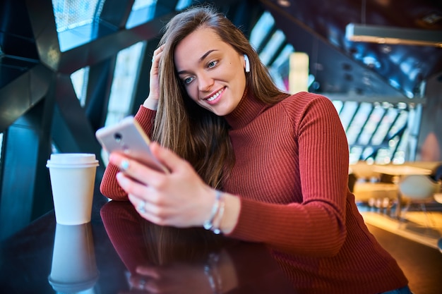 Feliz morena caucasiana jovem feliz com fones de ouvido sem fio