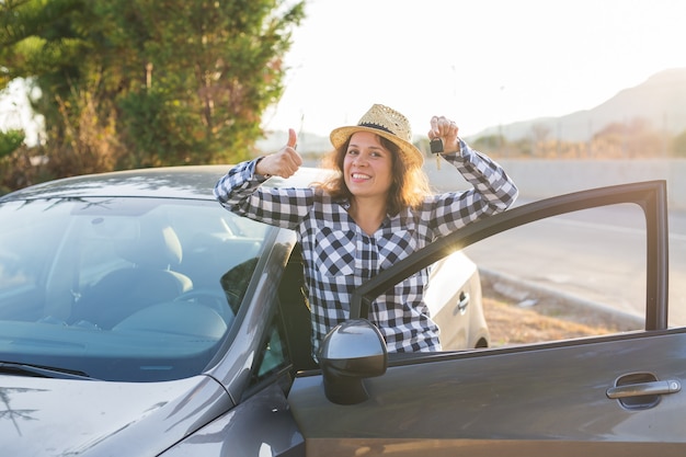 Feliz motorista de sucesso feminino segurando as chaves do carro.